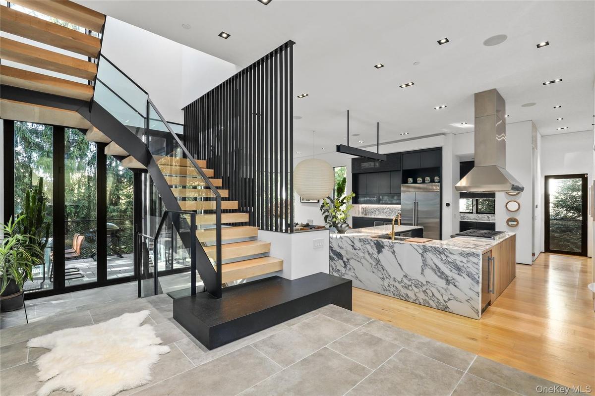 Modern Arrival -  striking new custom residence framed by stone, glass, steel and warm wood accents.