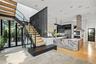 Modern Arrival -  striking new custom residence framed by stone, glass, steel and warm wood accents.