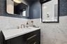 Powder Room – Statement finishes with wall-hung fixtures and custom stone sink.