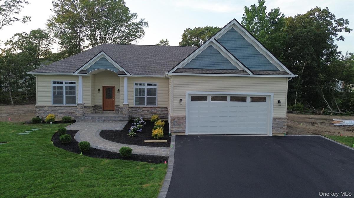 Craftsman house with asphalt driveway, stone siding, a front lawn, a shingled roof, and a garage. . For Marketing Purposes!