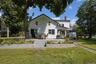 Back of house with a patio, a lawn, and a chimney