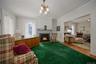 Living area with a lit fireplace, crown molding, wood finished floors, and a chandelier