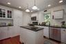 Kitchen featuring stainless steel appliances, hanging light fixtures, dark wood finished floors, recessed lighting, and glass insert cabinets