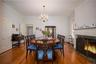 Dining space featuring crown molding, hardwood / wood-style flooring, a premium fireplace, a chandelier, and radiator