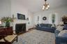 Living room featuring crown molding, radiator, wood finished floors, a chandelier, and a premium fireplace
