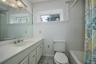 Full bath with plenty of natural light, vanity, shower / tub combo with curtain, and light tile patterned flooring