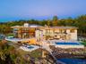 Back of property with a patio area, a swimming pool with hot tub, and a water view