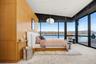 Carpeted bedroom with access to exterior, a water view, a wall of windows, and wooden walls