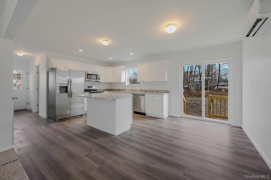 Kitchen with stone countertops, white soft close cabinets plus stainless appliances