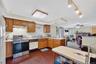 Kitchen featuring white appliances, a peninsula, a fireplace, light countertops, and open floor plan
