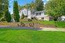 Tri-level home with a front lawn, stairs, and brick siding
