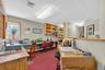 Office area featuring dark colored carpet, a baseboard heating unit, and built in desk
