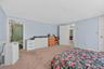 Bedroom featuring light colored carpet and connected bathroom