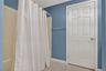 Full bathroom with shower / tub combo with curtain and tile patterned flooring