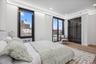 Bedroom featuring wood finished floors, radiator, a city view, recessed lighting, and baseboards