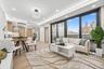 Living room with light wood-style floors, recessed lighting, baseboards, and a tray ceiling