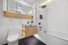 Bathroom featuring marble tiled flooring, toilet, a combined bath / shower with marble appearance, and vanity