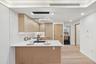 Kitchen featuring light brown cabinets, a peninsula, a sink, light wood-type flooring, and light countertops