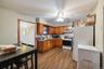 Kitchen featuring white fridge, ceiling fan, light hardwood / wood-style floors, stove, and decorative backsplash