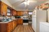 Kitchen with range, white fridge, tasteful backsplash, a baseboard heating unit, and light wood-type flooring