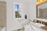 Full bath with vanity, ornamental molding, light tile patterned floors, and tiled shower / bath