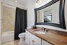 Bathroom featuring shower / bathtub combination with curtain, vanity, ornamental molding, and light tile patterned flooring