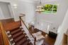 Foyer featuring stairway, dark wood finished floors, a chandelier, and crown molding