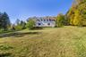 View of green lawn with view of wooded area
