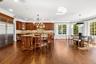 Kitchen featuring a chandelier, brown cabinetry, pendant lighting, crown molding, and recessed lighting
