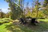View of grassy yard featuring a patio area and a fire pit