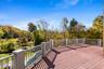 Wooden deck with an outdoor pool below