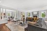 Living area featuring ornate columns, crown molding, dark wood finished floors, plenty of natural light, and recessed lighting
