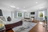 Bedroom featuring ornamental molding, multiple windows, recessed lighting, a high end fireplace, and wood finished floors