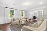 Living room featuring a decorative wall, wainscoting, french doors, ornamental molding, and dark wood-type flooring