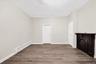Unfurnished bedroom featuring baseboard heating and wood finished floors