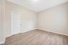Bedroom with light wood-style floors and a baseboard heating unit