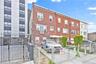 View of building exterior featuring fence private yard and a wall unit AC
