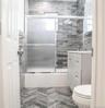 Full bath featuring vanity, toilet, and shower / bath combination with glass door