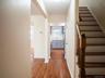 Hall featuring a sink, light wood-type flooring, baseboards, and stairs