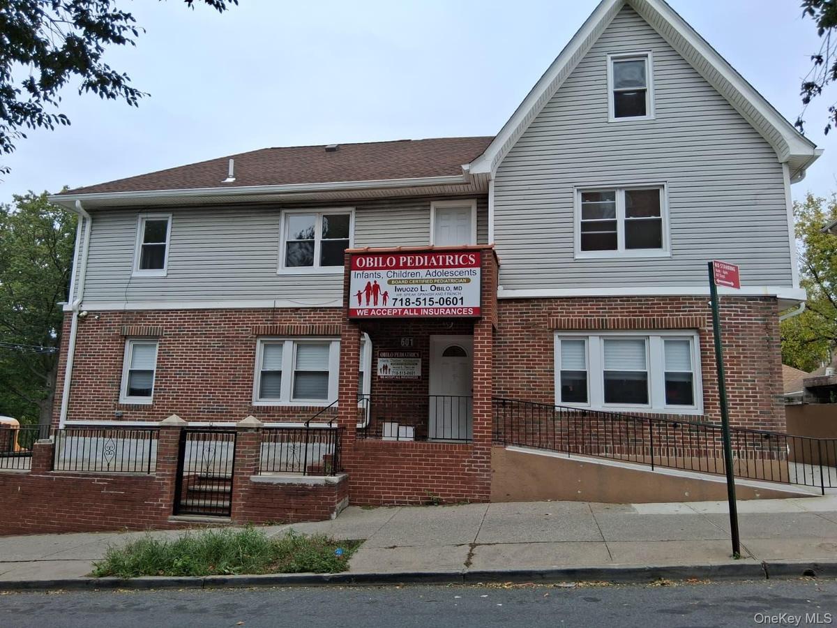 View of front facade featuring brick siding and a fenced front yard