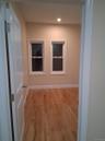 Hallway with light wood finished floors and recessed lighting