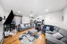 Living room featuring a chandelier, baseboard heating, light wood-style floors, a ceiling fan, and electric panel