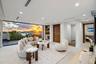 A spectacular third-floor sky lounge wrapped in floor-to-ceiling glass, capturing stunning sunset views over the water and city beyond. Elevated and d