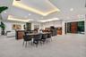 An expansive open living and dining area anchored by a sleek designer kitchen with statement island and warm wood cabinetry. Clean architectural lines