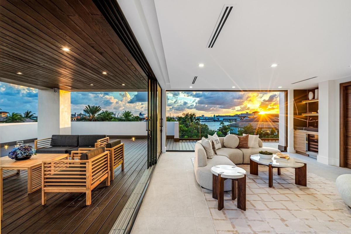 An extraordinary third-floor terrace offering sweeping views of the city skyline, sparkling waterways, and passing ships in the distance. Elevated and