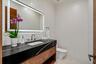 A sleek and stylish powder room featuring a floating vanity, bold contrasting finishes, and a clean, modern aesthetic. Thoughtfully designed, this ref