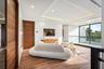 A serene modern bedroom retreat featuring clean architectural lines, a low-profile platform bed, and expansive windows framing tranquil water views. M