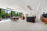 An expansive open-concept living and dining area defined by soaring ceilings, clean modern lines, and walls of glass that invite the outdoors in. Seam