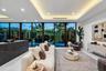 A stunning contemporary living room highlighted by sleek architectural lines, recessed ceiling lighting, and expansive walls of glass overlooking lush