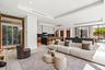 A refined open living area featuring clean architectural lines, custom millwork, and a seamless transition into the designer kitchen beyond. Bright an